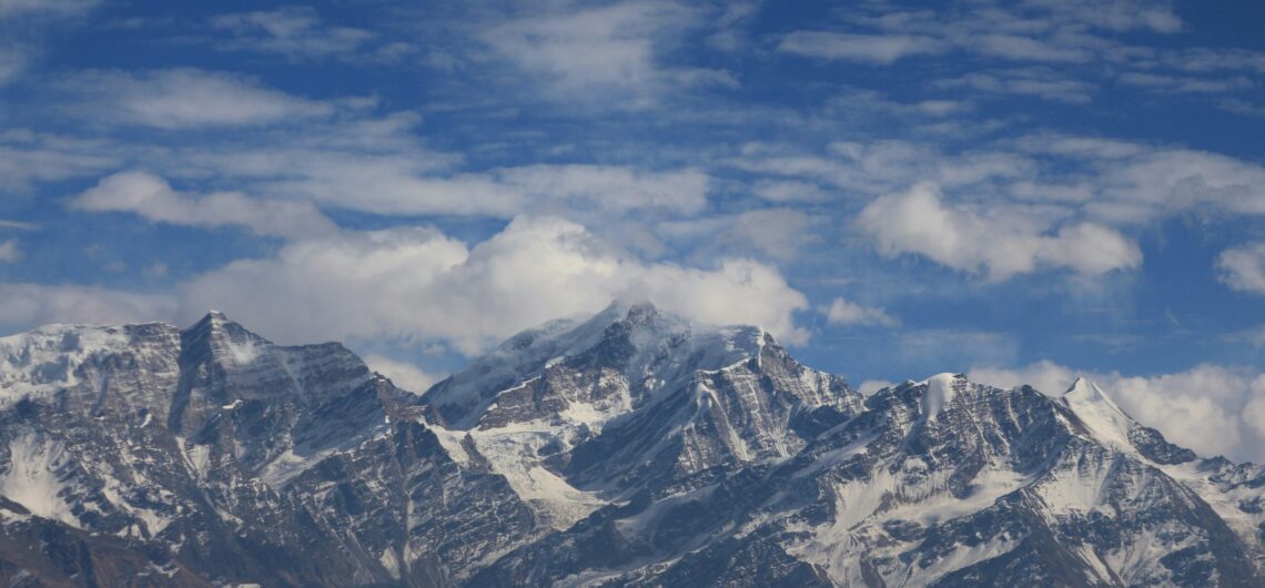 a view of a mountain range with clouds in the sky